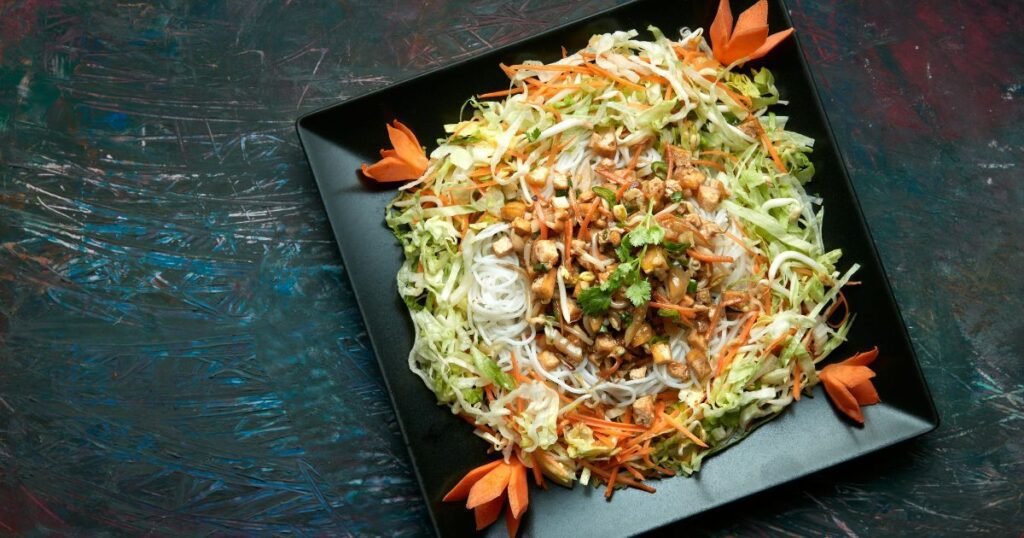 overhead view of chinese chicken salad on black dish on black table