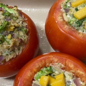 over head shot of three stuffed red bell peppers in dish.